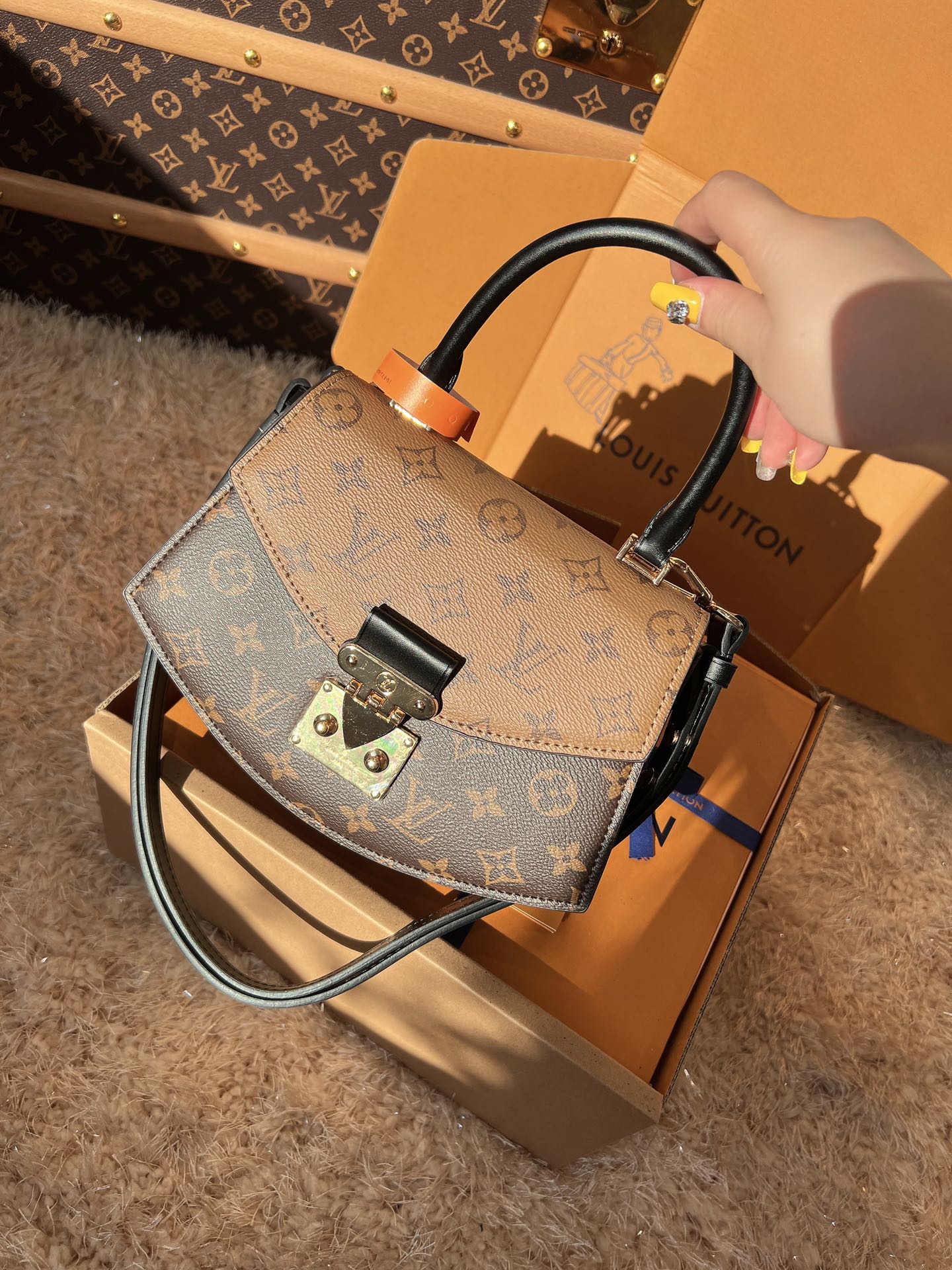 Louis Vuitton handbag with monogram pattern on a matching box